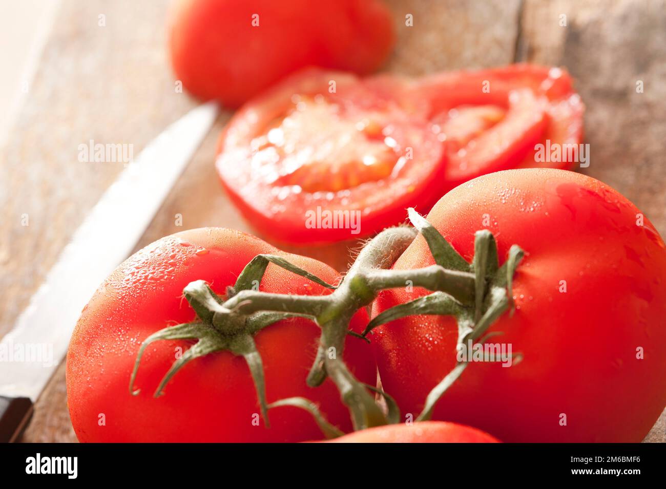 Close up view of succulent red tomatoes on vine Stock Photo