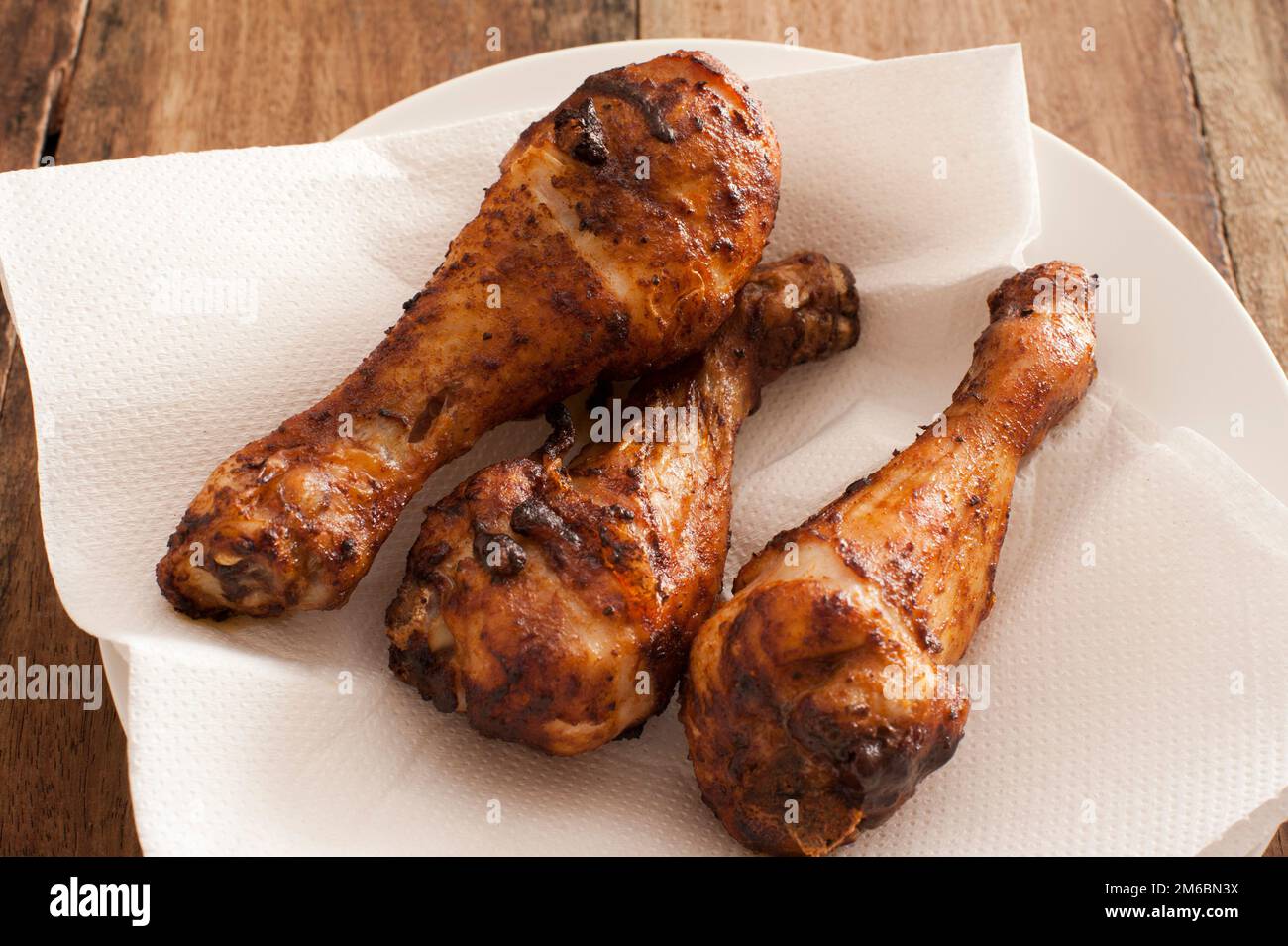 Three marinated spicy chicken drum sticks Stock Photo Alamy