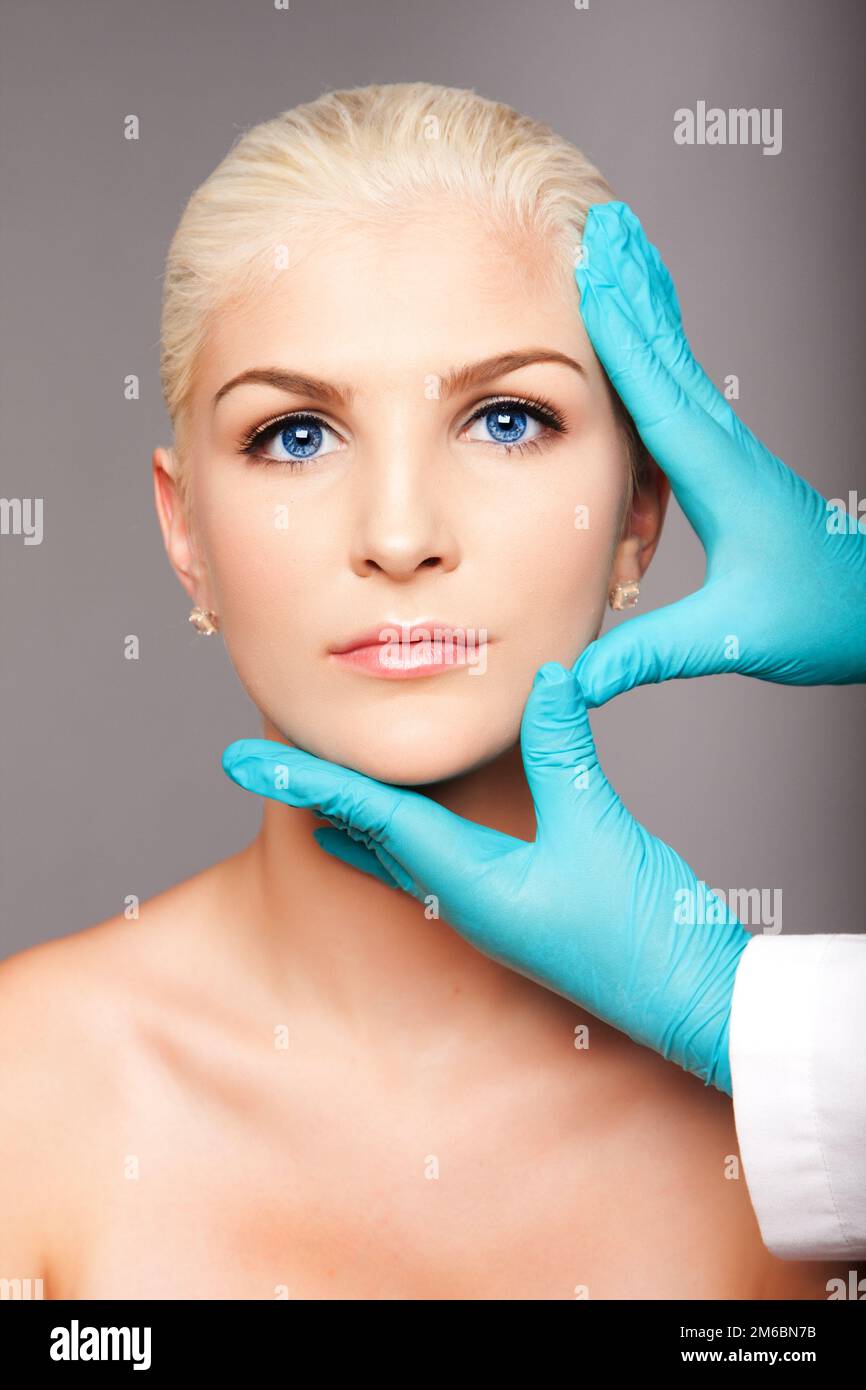 Cosmetic plastic surgeon touching aesthetics face Stock Photo