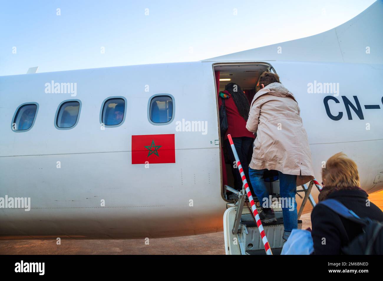 Ouarzazate, Morocco - Feb 28, 2016: passengers boarding airplane of Royal Air Morocco. People climbing ramp on background, rear Stock Photo