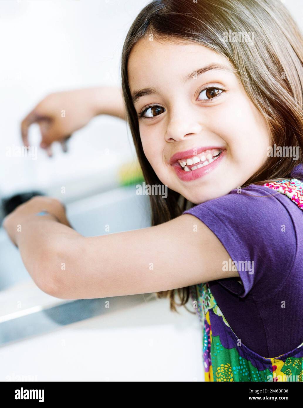 Kid washing hands in the kitchen Stock Photo
