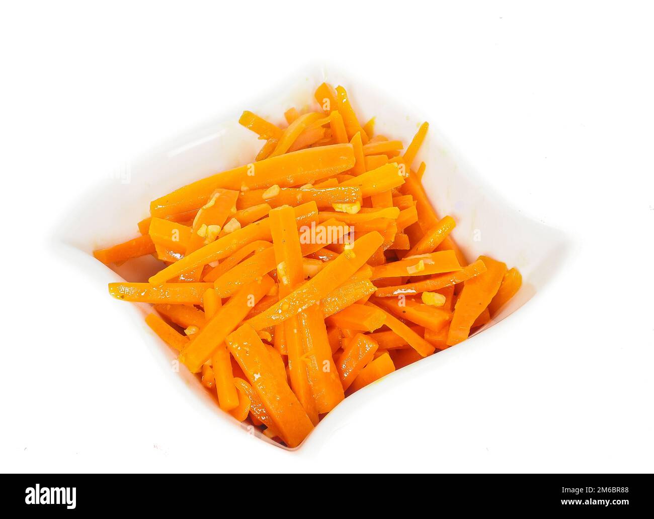 Closeup of carrot cut into julienne slizes in a beautiful white bowl against white Stock Photo