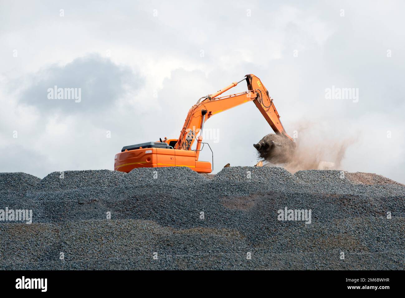 Digging Rough Stone Digger collecting stone for road building Stock Photo - Alamy