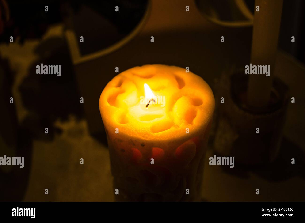 White Candle Against Dark Background photograph of a lit white candle