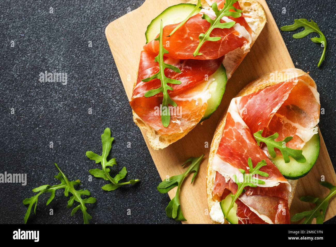 Open sandwiches with cream cheese, prosciutto, cucumber and arugula