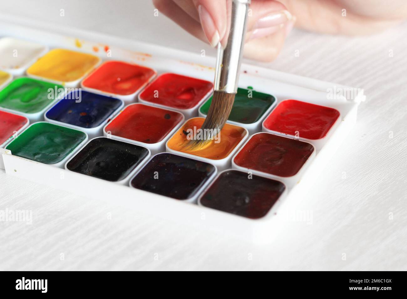 Process of Painting with watercolors, a palette and brush in hand Stock