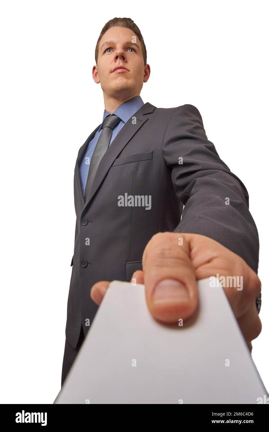 Isolated young attractive successful seriously businessman hands over a business card. Low angle shot with copy space. Stock Photo