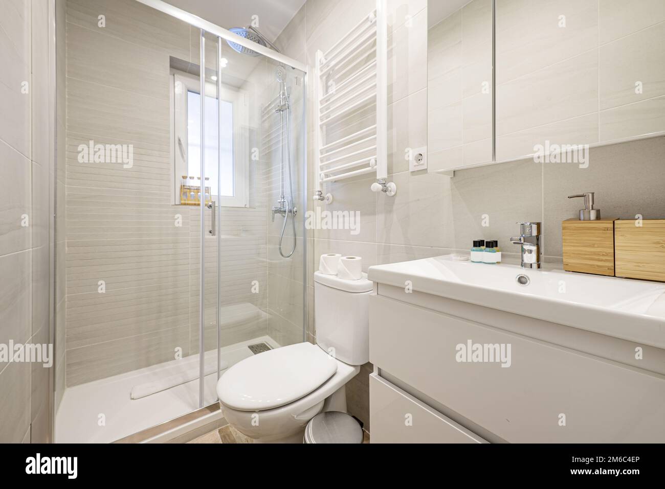 Small bathroom with white porcelain sink on wooden chest of drawers