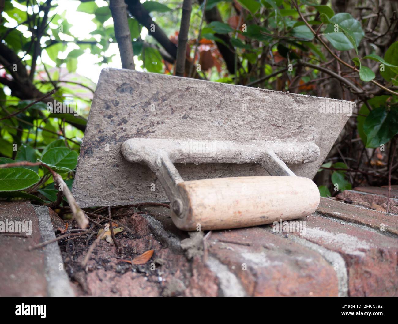 A plastering tool flat trowel resting on a wall Stock Photo