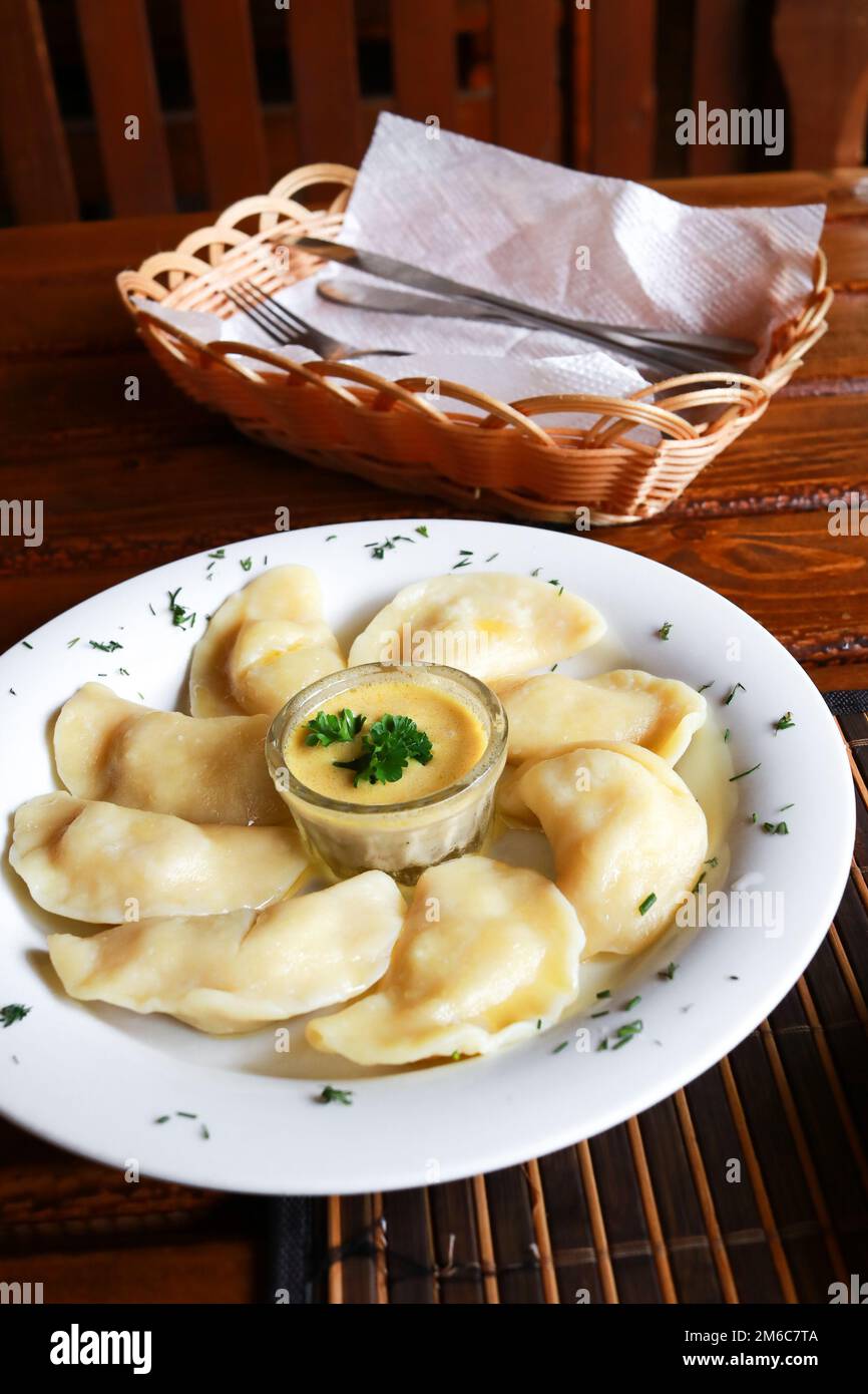 Ukrainian and Russian dish vareniki with mashed potatoes and sour cream and mushroom sauce on