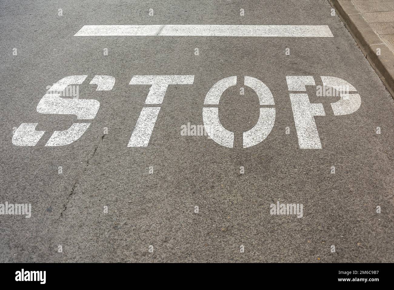 On the asphalt roadway marked the road marking STOP Stock Photo