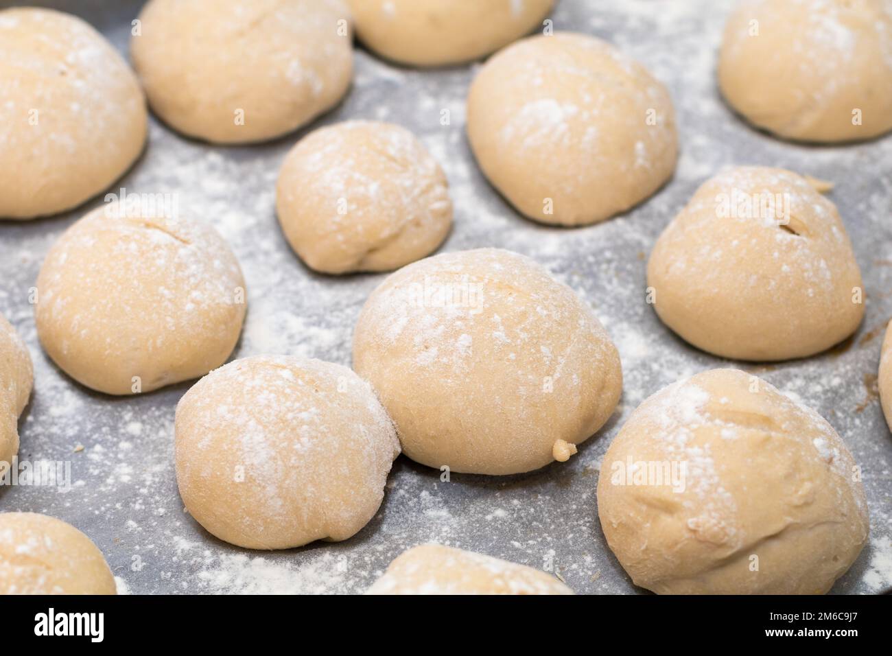 Freshly made white bread rolls proving Stock Photo Alamy