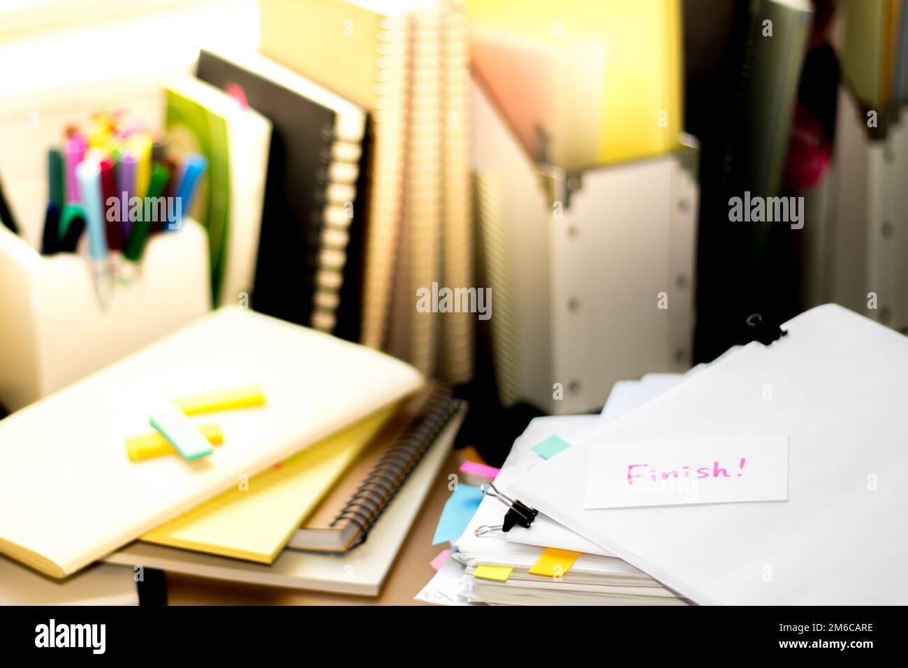 Finish; Stack of Documents. Working or Studying at messy desk. Stock Photo