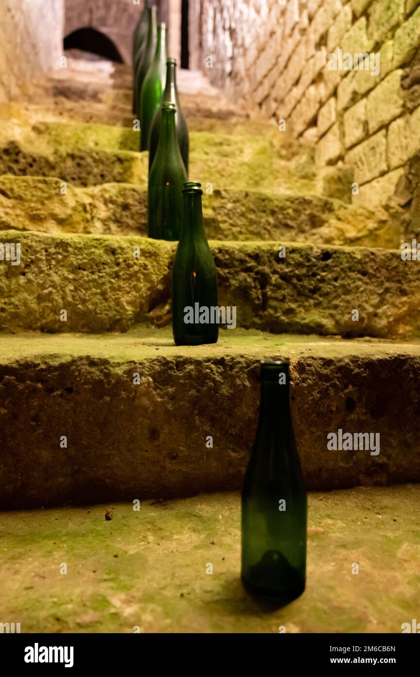 Collection of different sizes of champagne bottles is caves, making