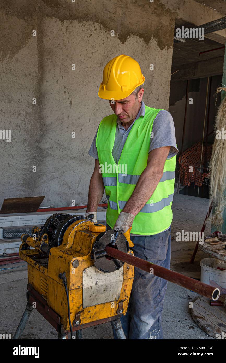 Technician is grooving steel pipe. Iron pipe master working iron pipes