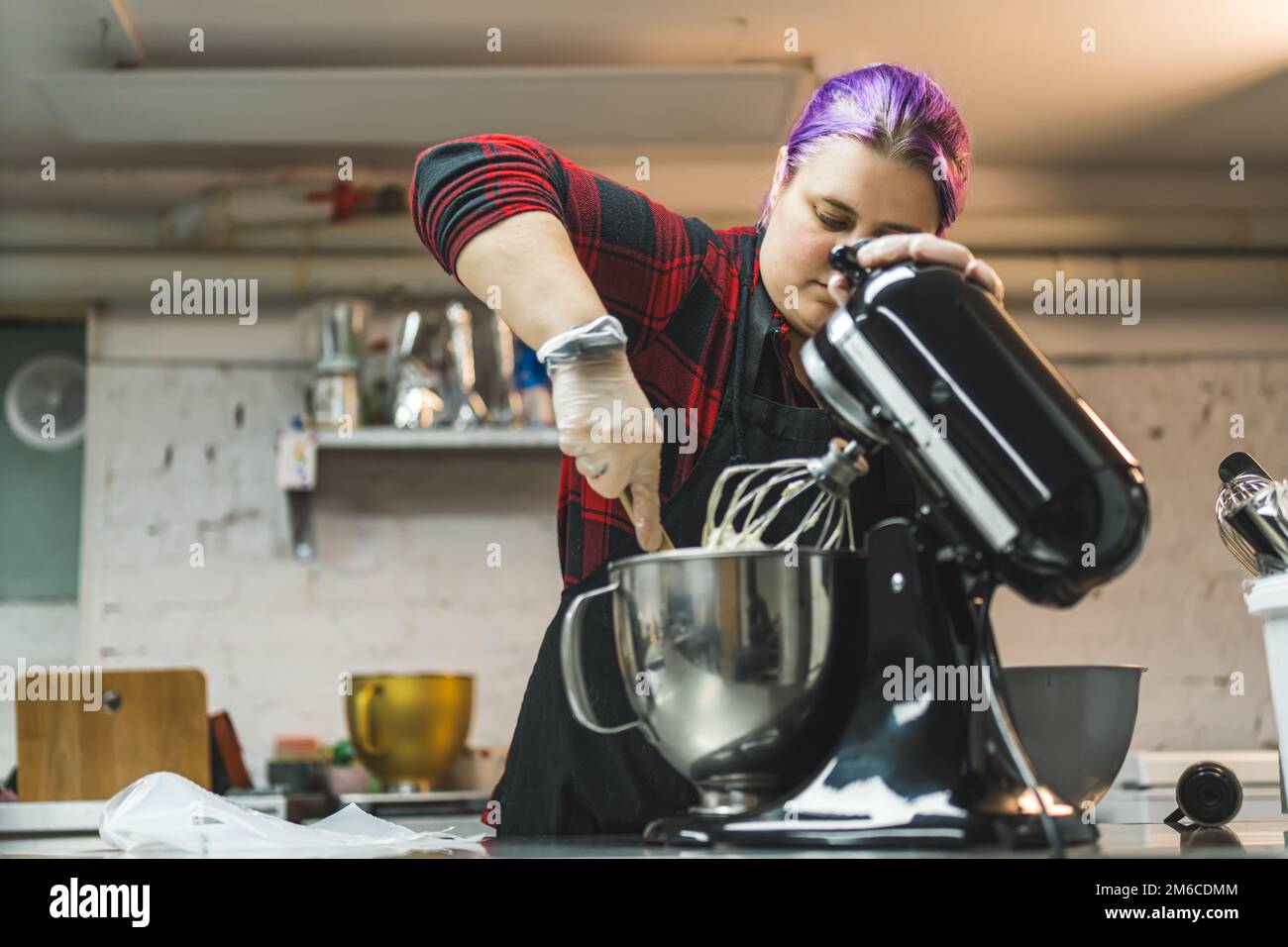 Person baking cookies. Professional pastry cook scooping out the dough out of food processor. Indoor copy space. High quality photo Stock Photo