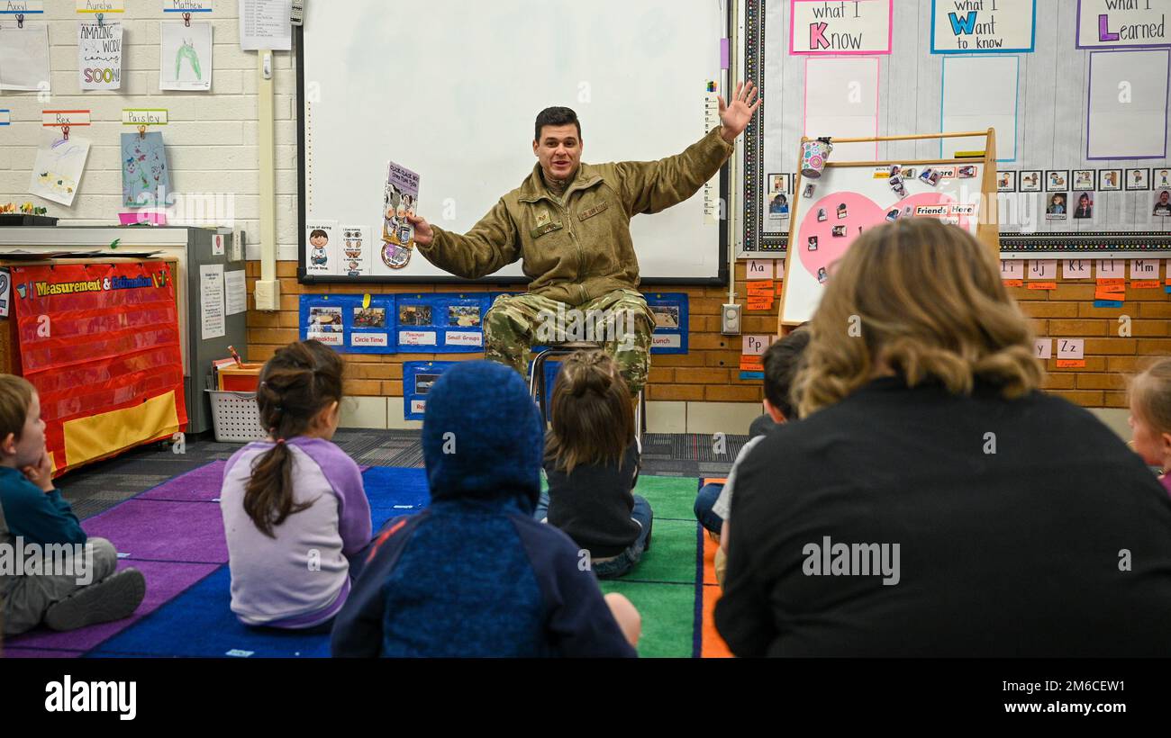 Staff Sgt. Janpaul Nieves, 729th Air Control Squadron, reads with students during a Heroes