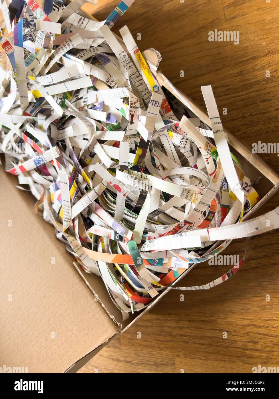 pile of shredded paper documents newspaper inside cardboard box Stock
