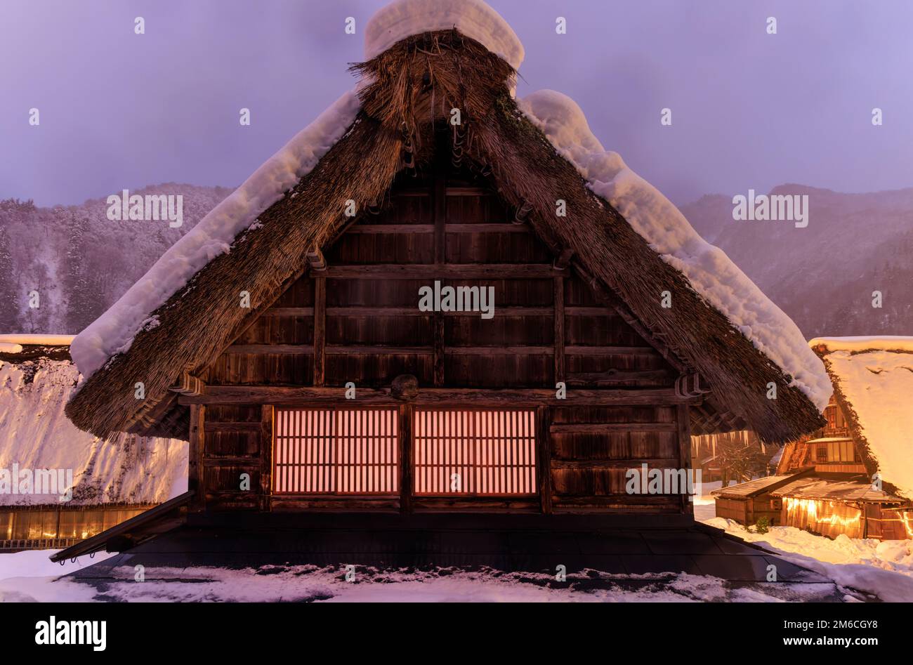 Snow covered thatched roof on traditional Japanese farmhouse at dawn Stock Photo