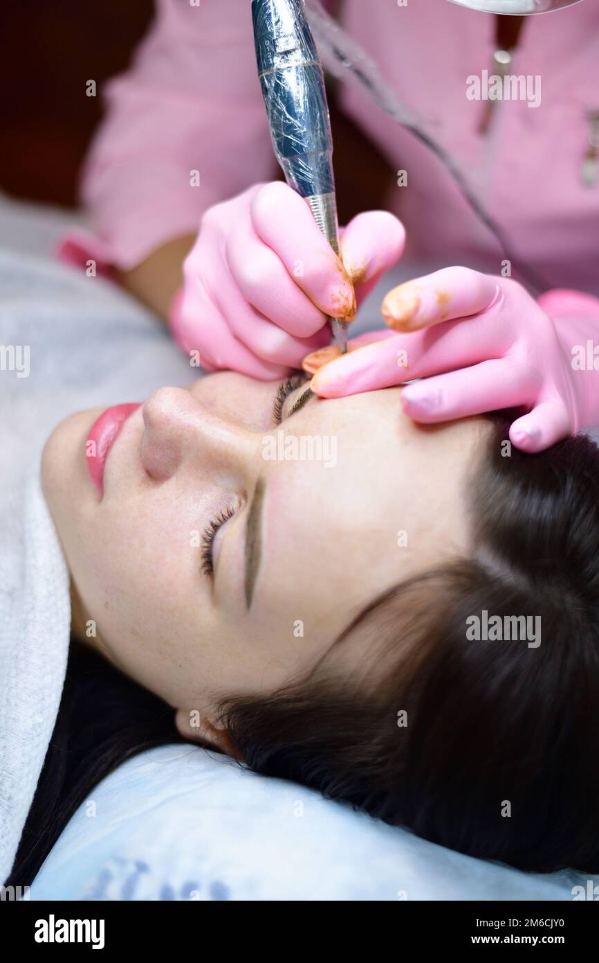 Doctor does cosmetic procedures on girl's face Stock Photo