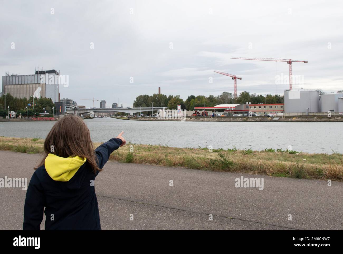 View of the industrial zone. Teenage girl shows the new buildings in the city. Copy space Stock Photo