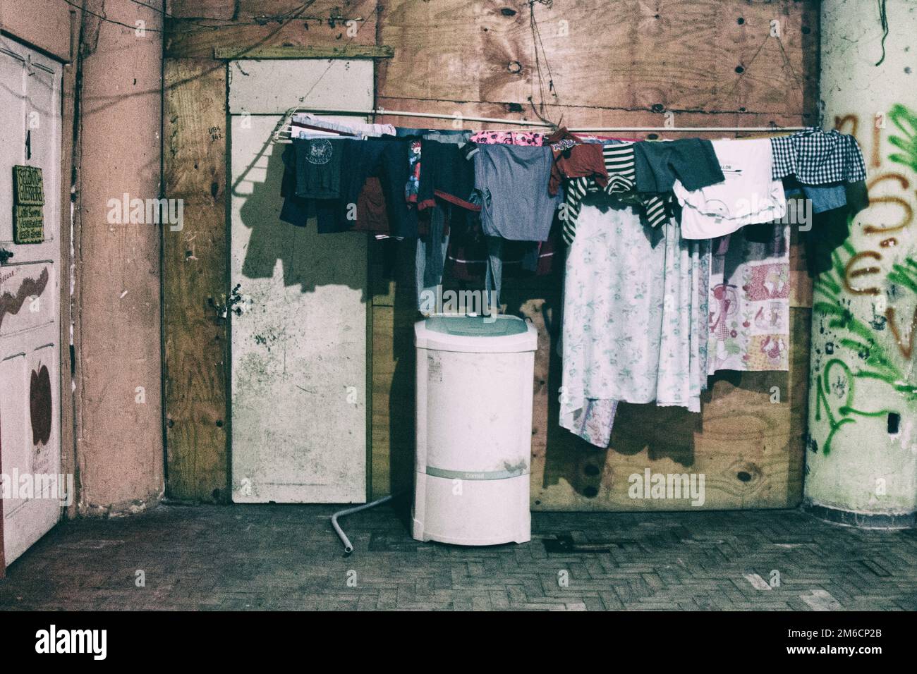 Washing machine and clothes hanged to dry on the outside of a decayed apartment. Stock Photo