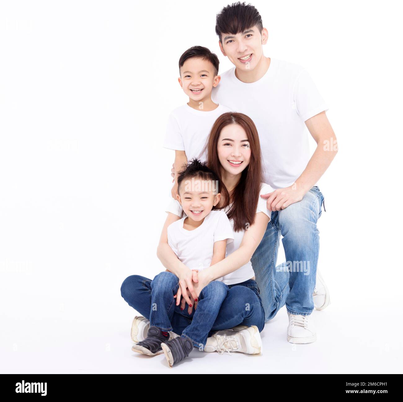 Happy Asian family and kids sitting on white floor Stock Photo