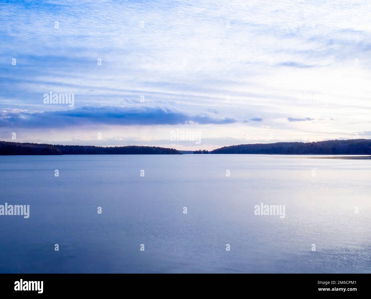 Beautiful calm river and cloudy blue sky, late afternoon. Winter on the Damariscotta River, Maine. Damariscotta is the Oyster capital of New England. Stock Photo