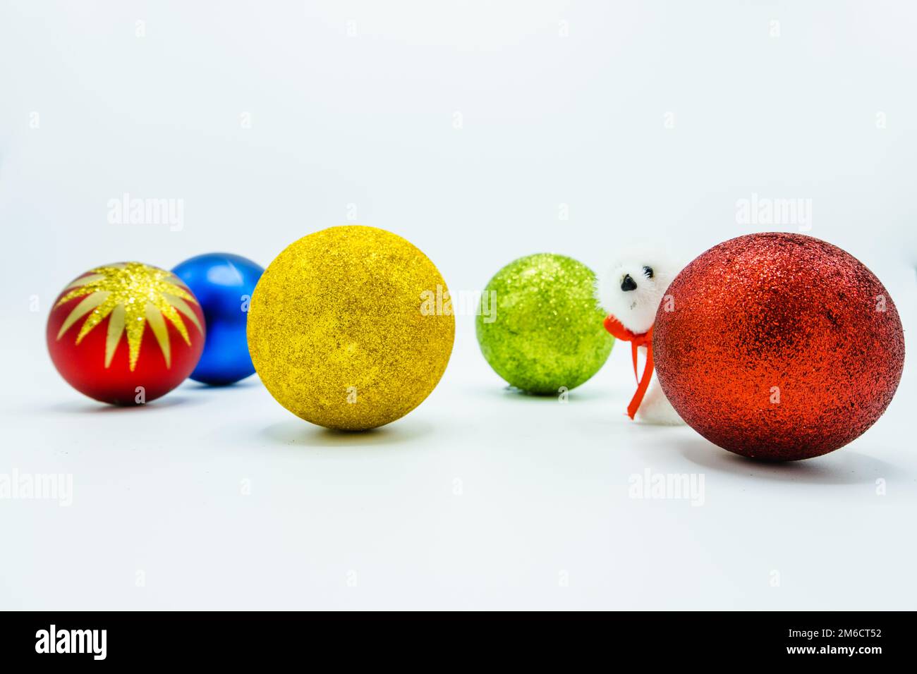 Red, green, gold, blue christmas balls and a white polar bear toy. Stock Photo