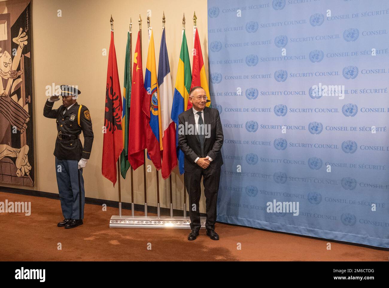 Ecuador Ambassador Hernan Perez Loose stands next to his country flag