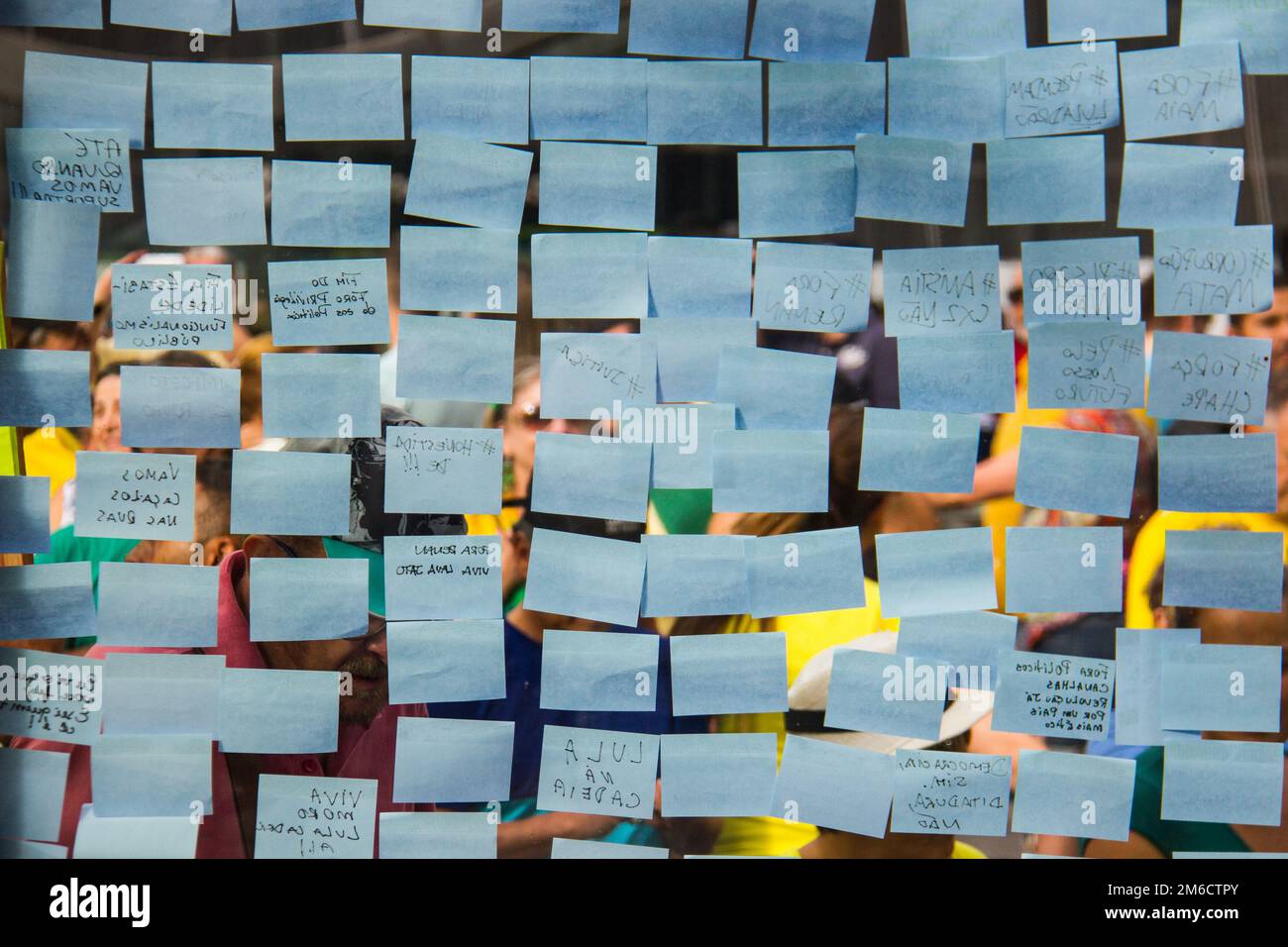 Blue note sticky notes on a glass wall. Stock Photo