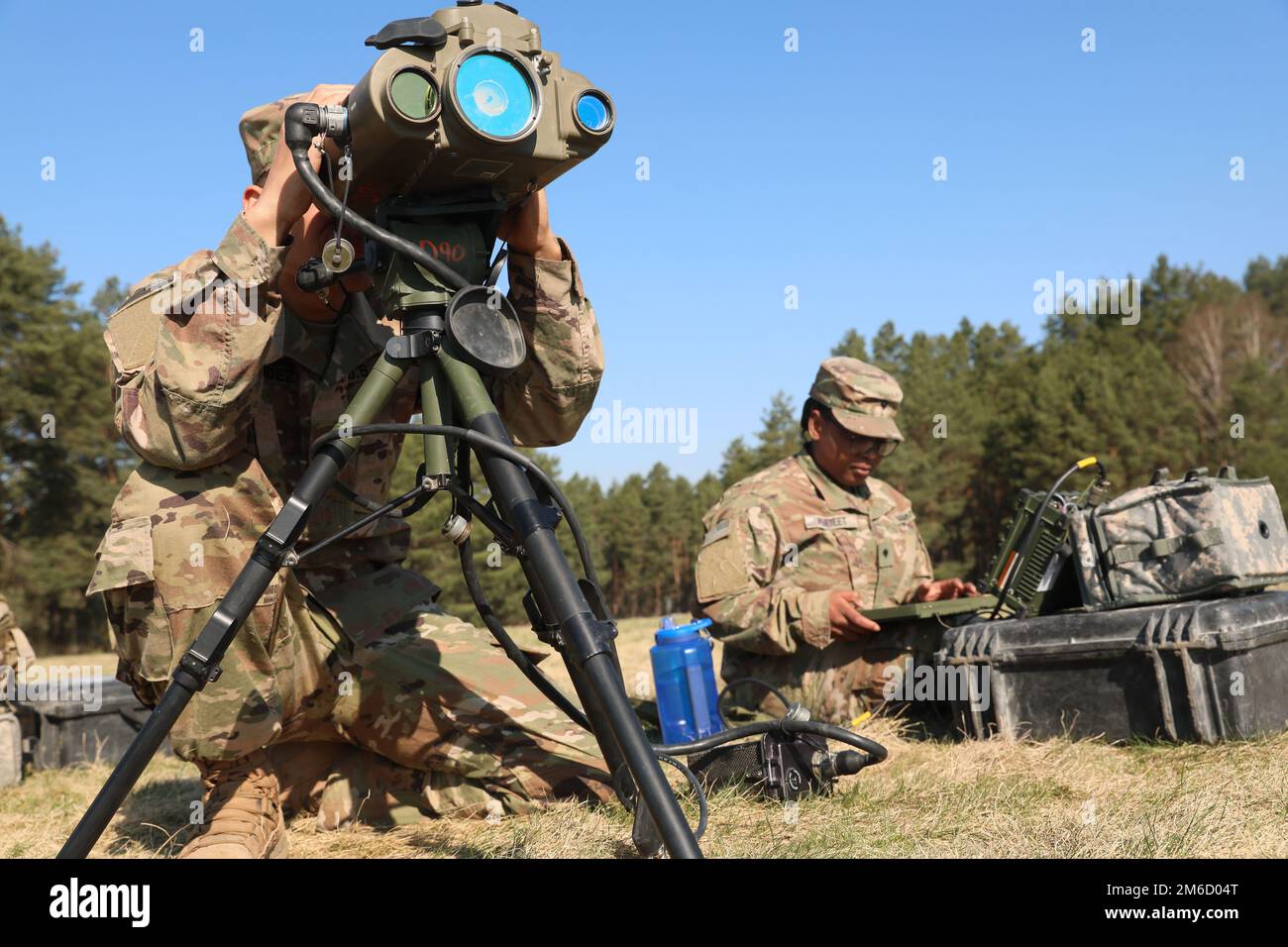 U.S. Army 1st Lt. Dan Hernadez, a Guancia, Puerto Rico, native and fire support officer (left), Spc. Kyria Perteet a Watson, Louisiana native and fire support specialist (right) assigned to 3rd Armored Brigade Combat Team, 4th Infantry Division (3/4 ABCT), use a lightweight laser designator range finder to send a 10-digit-grid to process fire missions at Drawsko Pomorskie, Poland, April 23, 2022. The 3/4th ABCT is among other units assigned to V Corps, America's forward-deployed corps in Europe that works alongside NATO allies and regional security partners to provide combat-credible forces; e Stock Photo