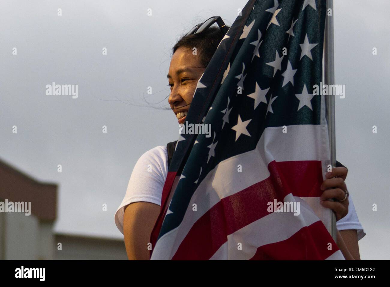 A U.S. Air Force service member holds an American flag at the 9th Annual Memorial for the Bataan Death March at Kadena Air Base, Japan, April 23, 2022. The event commemorated casualties and survivors from the 1942 Bataan Death March, during which approximately 76,000 Filipino and American service members endured a nearly 70-mile march during a prison transfer. Stock Photo