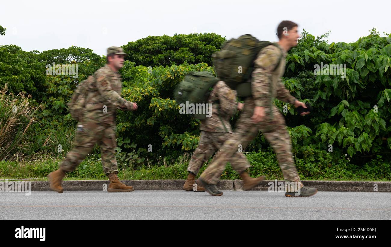 U.S. Air Force service members ruck down the road during the 9th Annual Memorial for the Bataan Death March at Kadena Air Base, Japan, April 23, 2022. The 8.5-mile run/ruck/walk was held to commemorate the American and Filipino servicemen who were marched nearly 70 miles to prison camps after surrendering at the Bataan Peninsula in April of 1942. Stock Photo