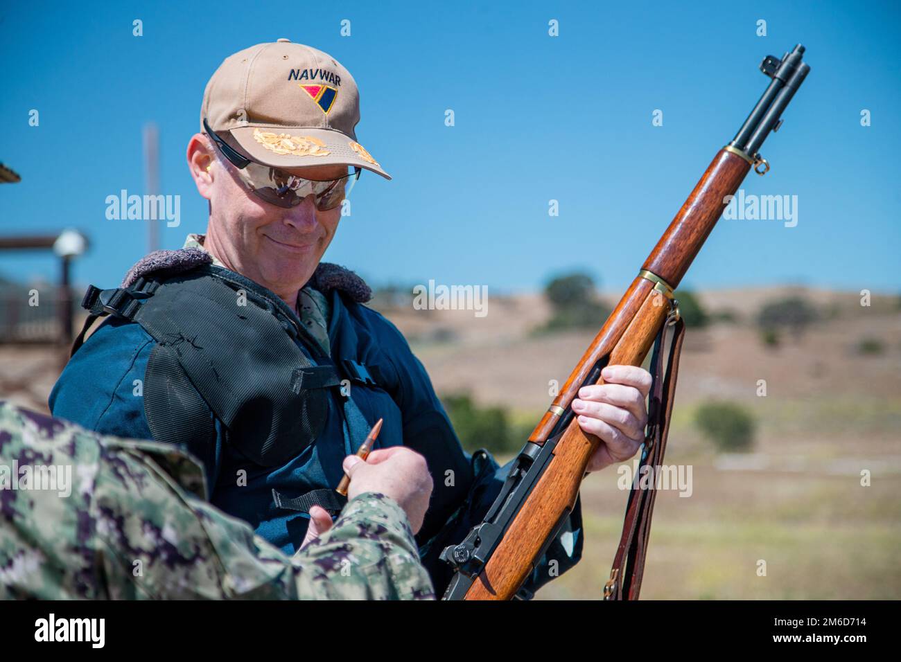 U.S. Navy Rear Adm. Douglas Small, the commander of Naval Information Warfare Systems Command, prepares to insert a round into an M1 Garand rifle for the first shot to kick off the Fleet Forces Pacific Area Rifle and Pistol Matches at Range 214 on Marine Corps Base Camp Pendleton, California, April 23, 2022. The U.S. Navy Marksmanship Team conducts rifle and pistol matches each year and trains hundreds of sailors in service rifle and pistol marksmanship, small arms safety, and competition rules and procedures. Stock Photo