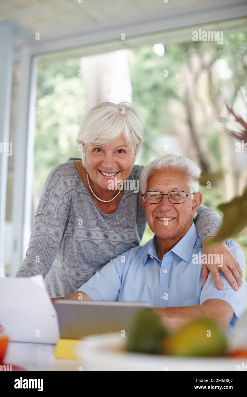 We are in charge of our finances. a senior couple using a digital tablet and holding paperwork. Stock Photo