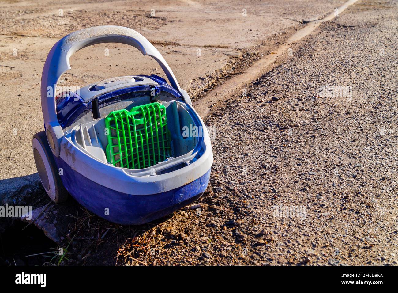 An old broken plastic vacuum cleaner has been thrown away and is