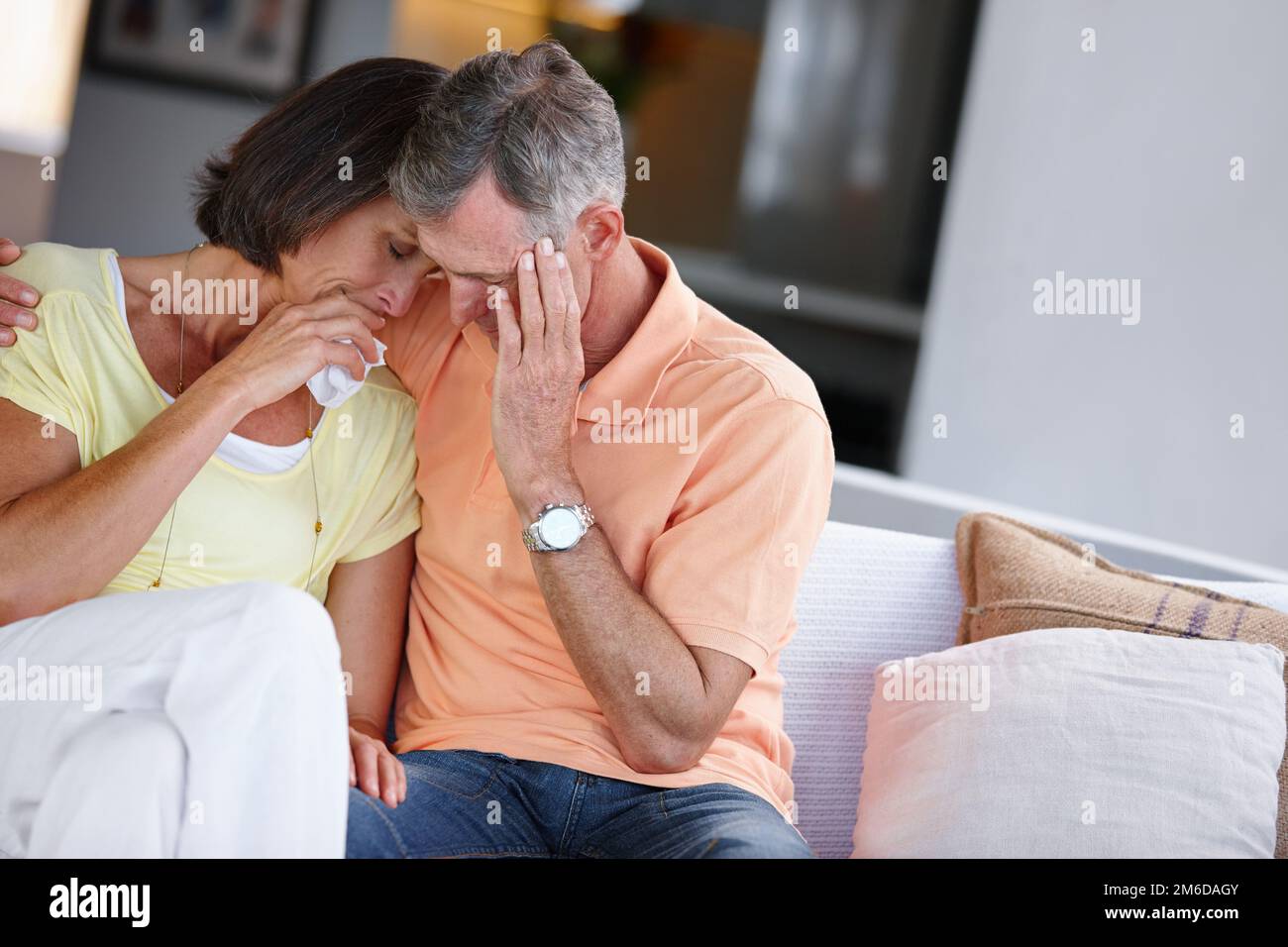 Dealing with their grief together. a mature married couple looking sad and distraught while sitting beside ach other. Stock Photo