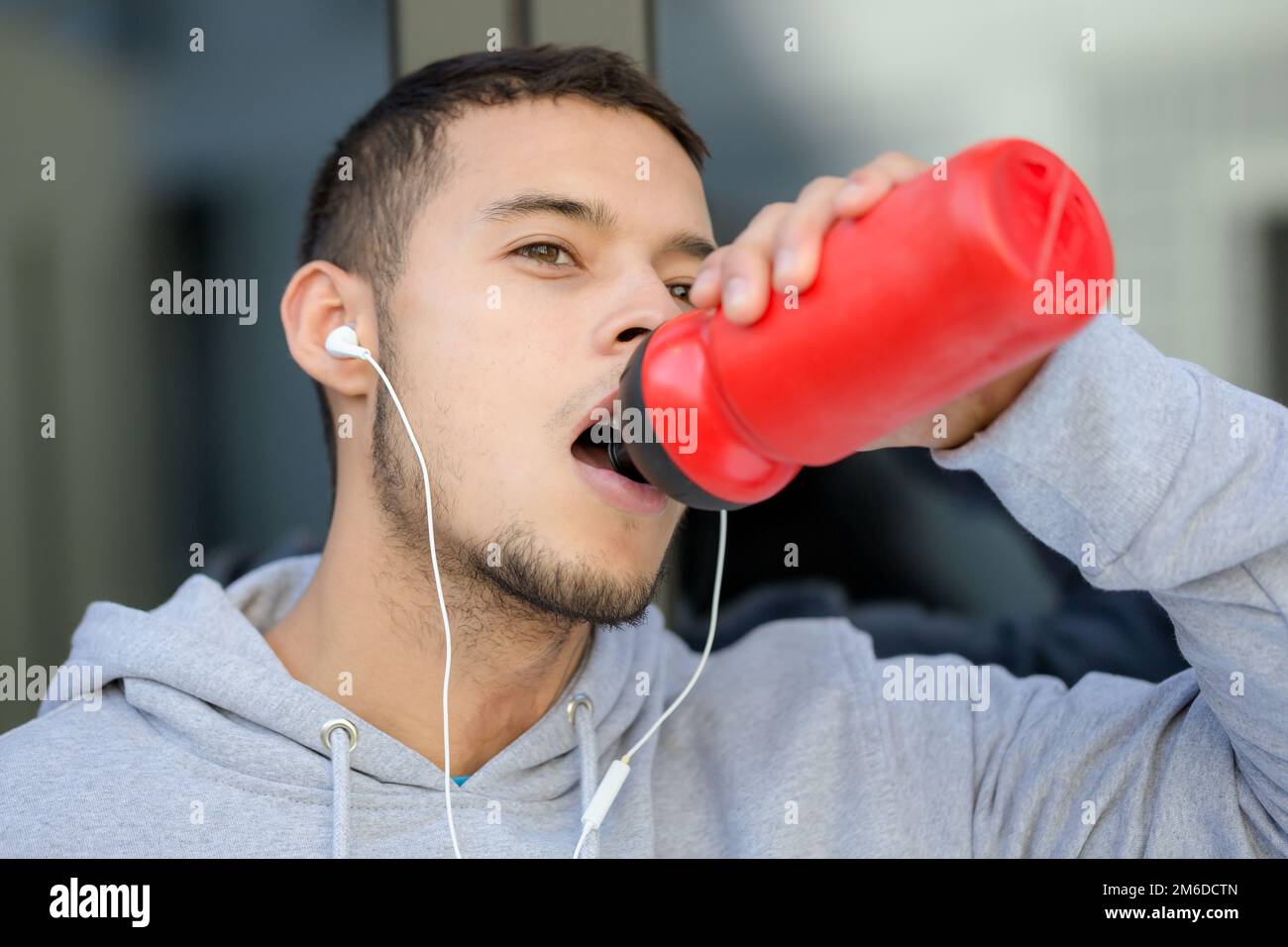 Drinking water sports training fitness young latin man winter running jogging Stock Photo