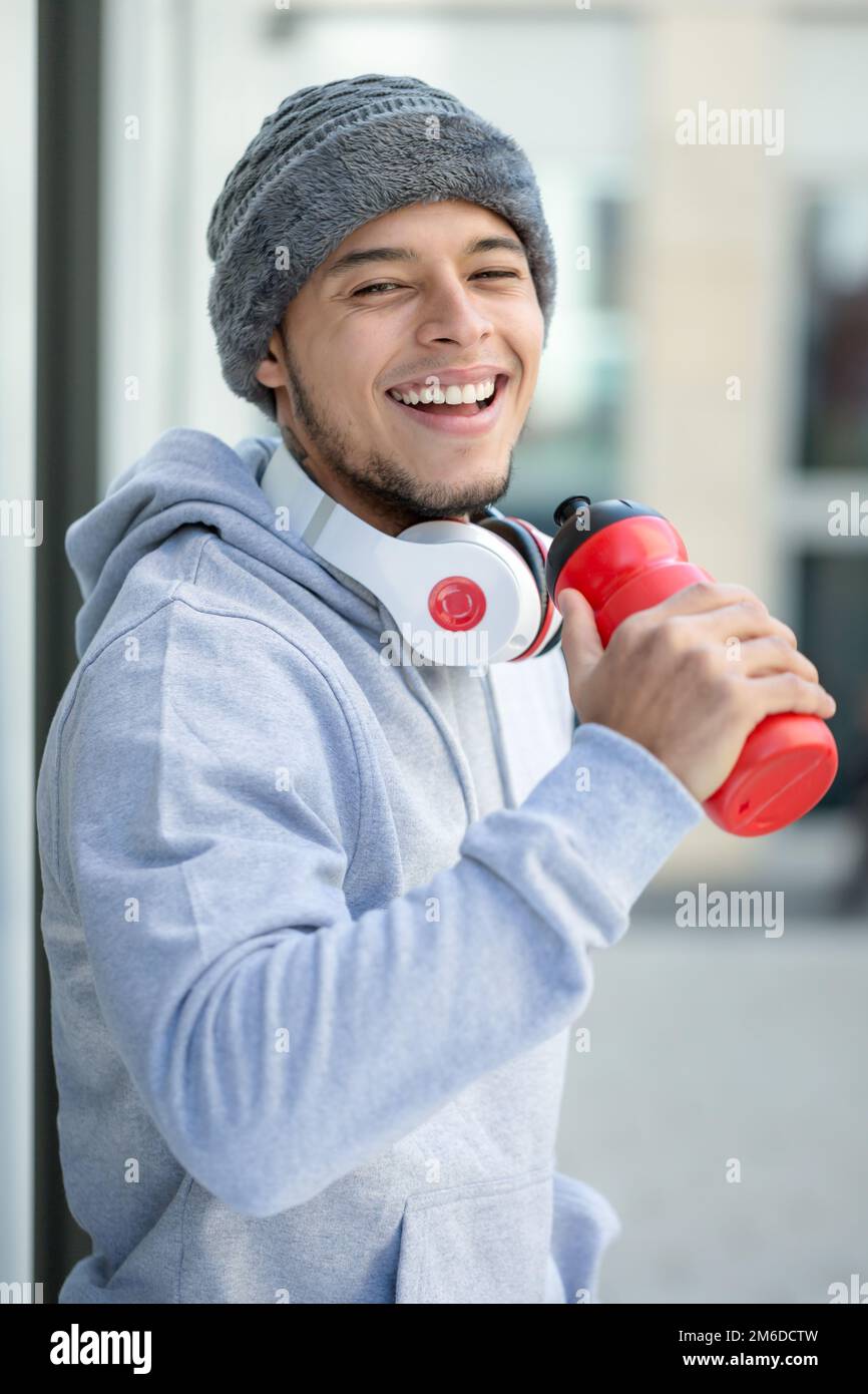 Smiling young latin man drinking sports training portrait format fitness winter Stock Photo