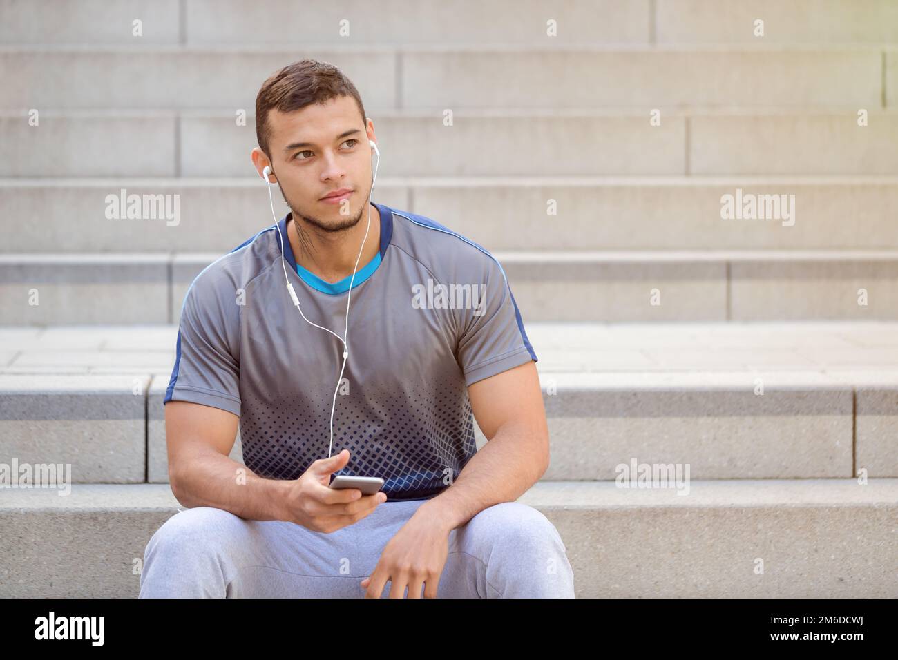 Listening to music young latin man looking up smartphone listen copyspace copy space Stock Photo