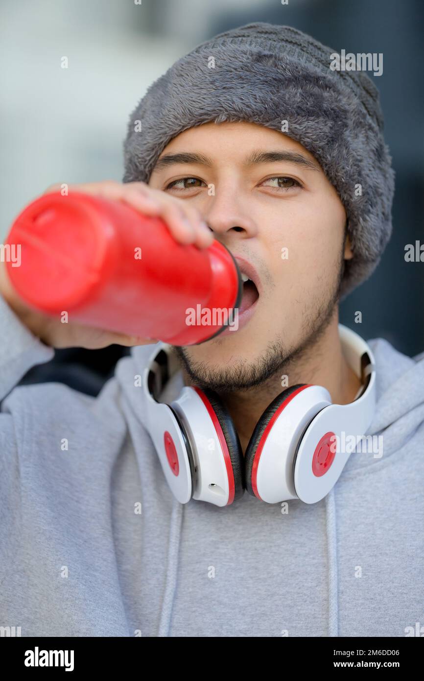 Young latin man drinking water portrait format winter sports training fitness Stock Photo
