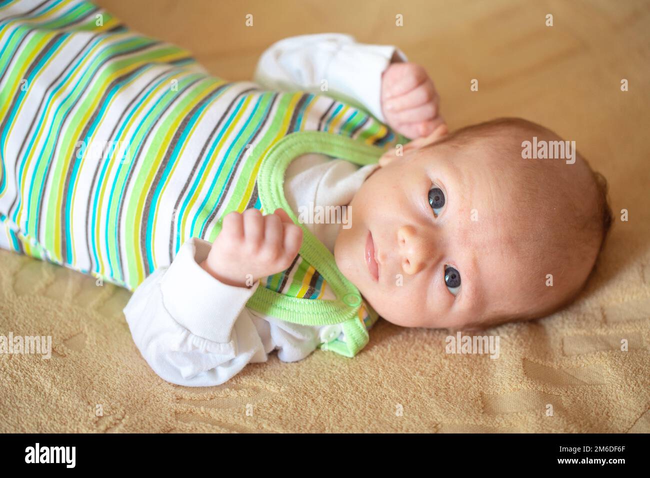 A breastfed baby wrapped in a diaper lies on the sheet Stock Photo Alamy