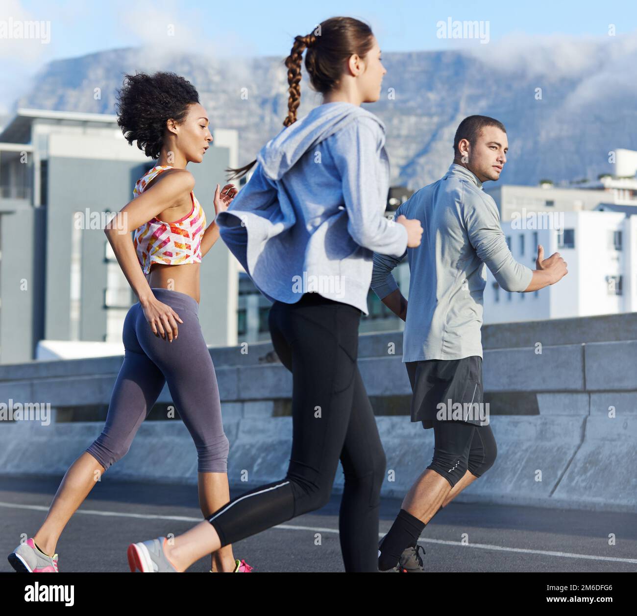 The jogging pack. a group of friends jogging together through the city. Stock Photo