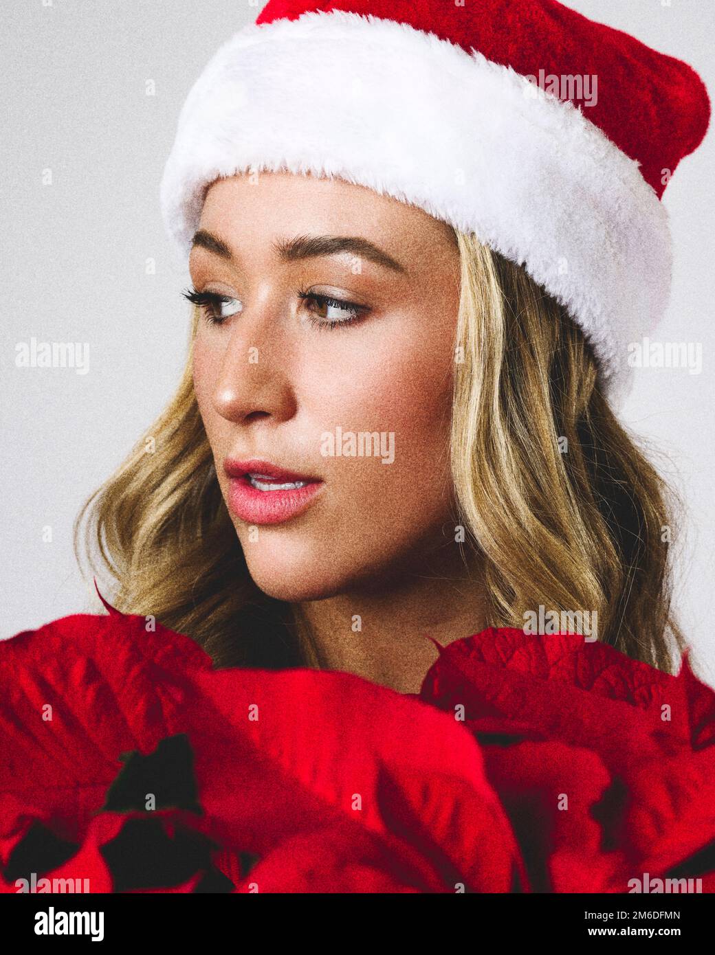 Close up Young Woman Holding Poinsettia Plant | Santa Hat Stock Photo