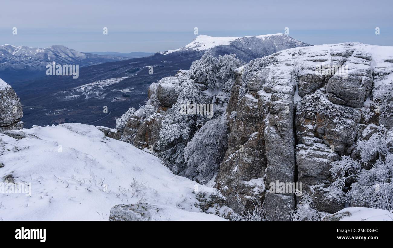 Rocks on Southern Demerdzhi mountain in snow after blizzard in early spring. And view of Chatyr-Dag. Crimea Stock Photo