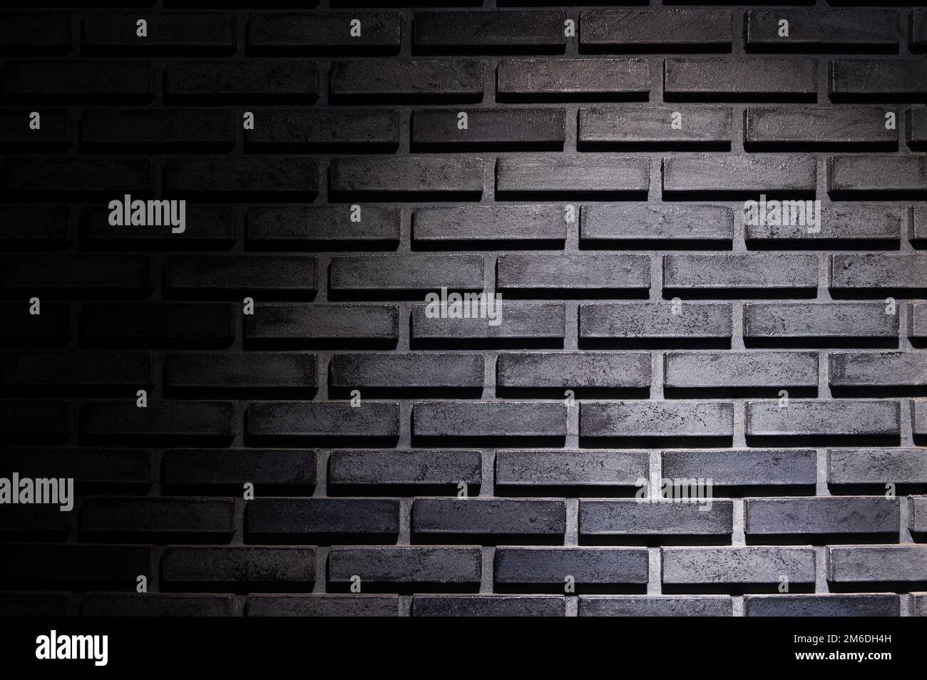 Black brick wall background with light spot Stock Photo