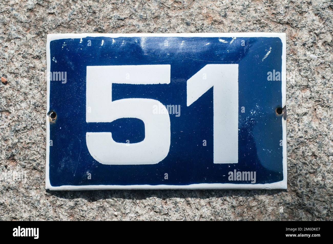 Weathered grunge square metal enameled plate of number of street address with number 51 closeup Stock Photo