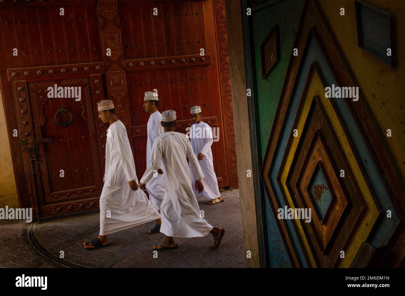 Young Omani men wearing traditional Arab clothes in the Souk at Nizwa, Oman, Stock Photo