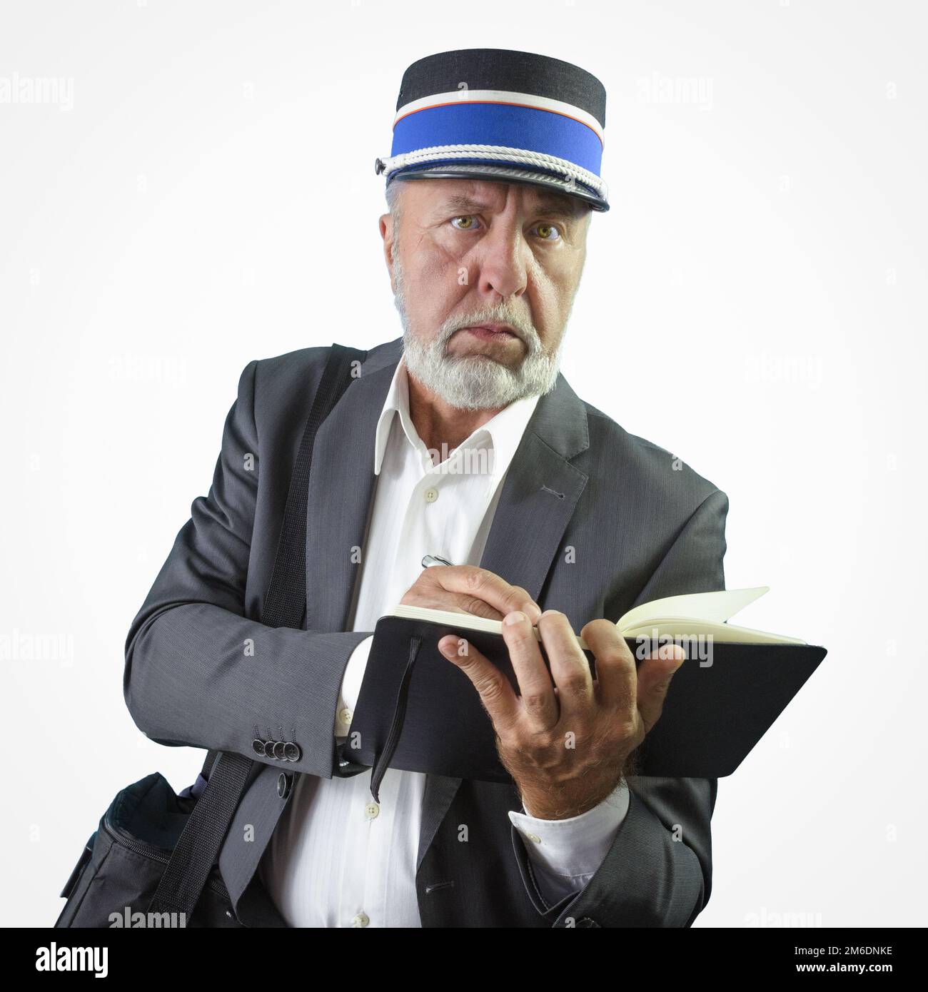 An old train conductor writes a note with a pen in his paper notebook png Stock Photo
